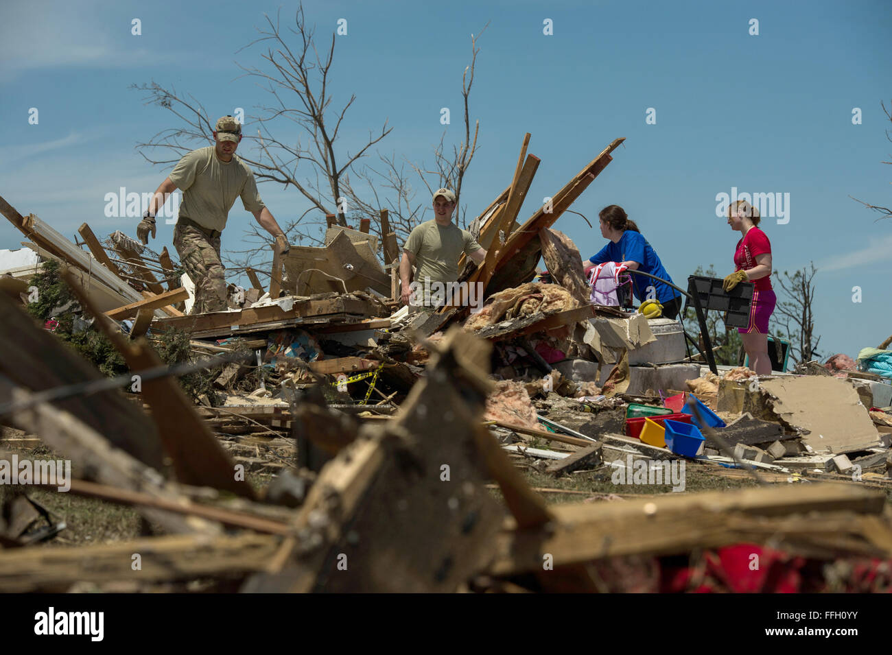 Stati Uniti Air Force Capt. Van Blaylock, sinistra, Senior Airman Joshua Jacobs, il centro sinistra, giunto di attacco terminale controllore assegnato all'aria 146supportano operazioni squadrone, aiuta a resident Alyson Tinney, al centro a destra e Elise Hopkins, a destra la ricerca attraverso i detriti alla ricerca di oggetti recuperabili Maggio 22, 2013, Moore, Okla. Lunedì un EF-5 tornado, con venti di raggiungere almeno 200 mph, ha viaggiato per 20 miglia, lasciando un due-miglio-largo sentiero di distruzione, case di livellamento, la frantumazione di veicoli e uccidendo più di venti persone. Più di 115 Oklahoma guardia nazionale sono state attivate per assistere in th Foto Stock