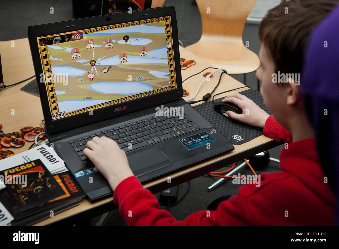 Giovane di riproduzione video del computer gioco sul portatile Asus - USA Foto Stock