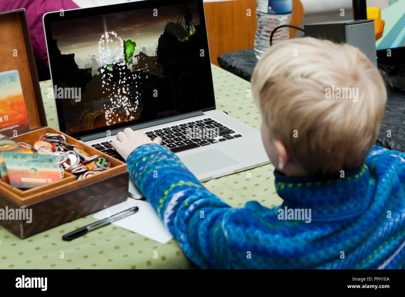 Bambino che gioca computer video gioco su Apple PowerBook laptop - USA Foto Stock