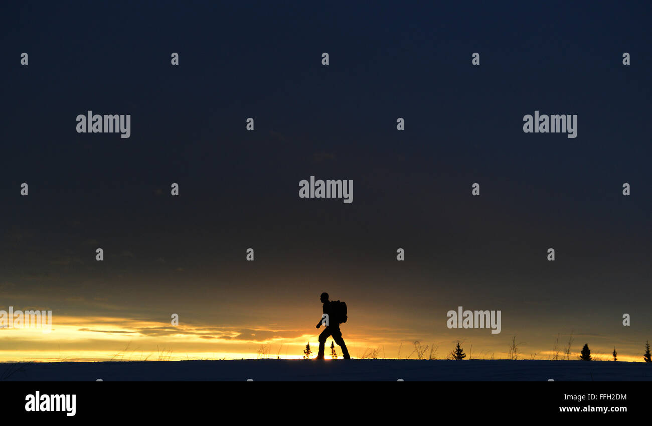 Il sergente Seth Reab, un istruttore di sopravvivenza artica presso la Eielson Air Force base, ha fatto trekking su una montagna come parte dell'addestramento fisico in corso e della preparazione basata su scenari per insegnare abilità di sopravvivenza al personale dell'aeronautica militare. Foto Stock