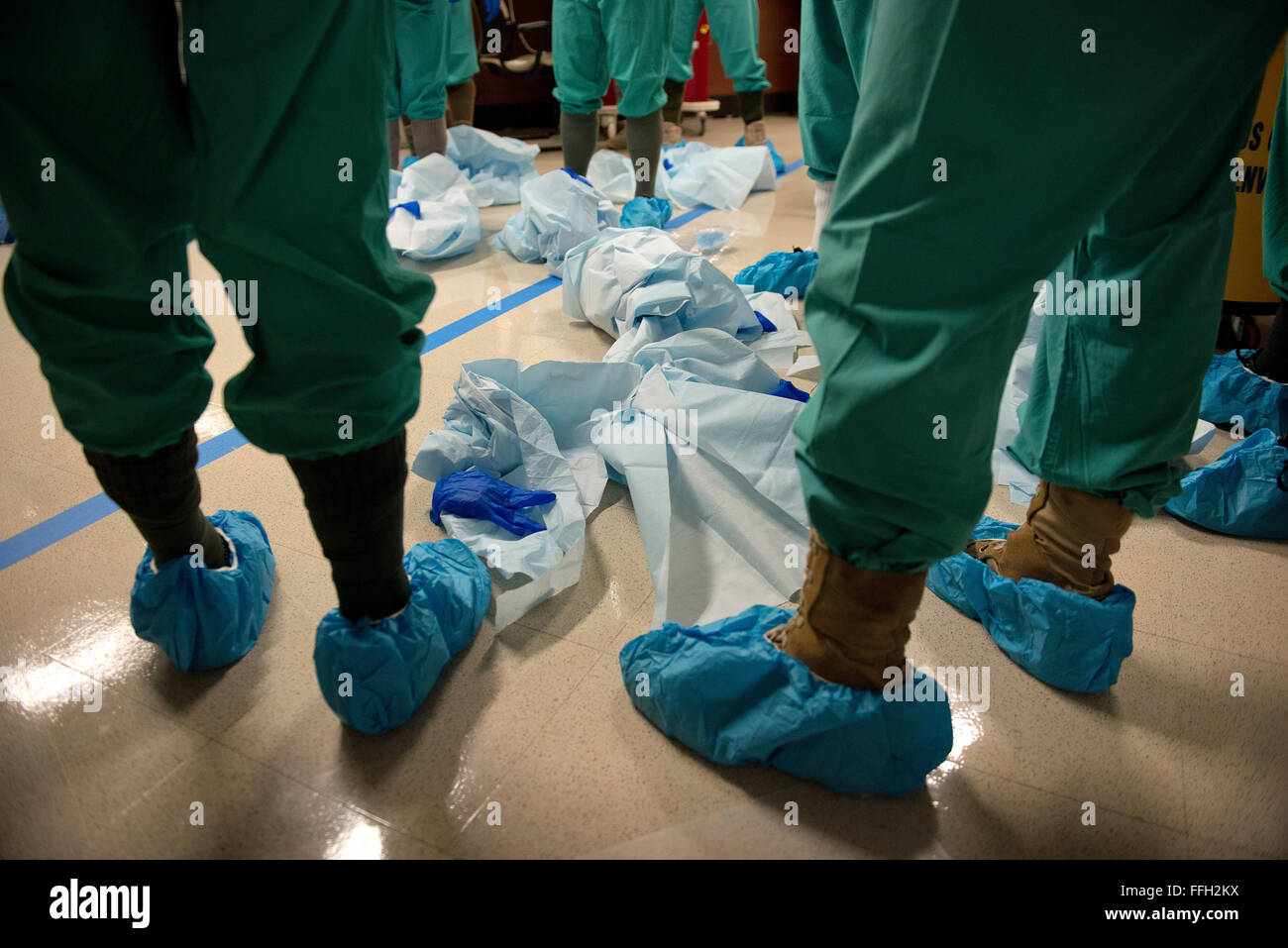 I membri del servizio assegnato ai militari per 30 Stati Ebola medical support team pratica indossabilità e la levata equipaggiamento protettivo personale. L'apparecchiatura è essenziale per la prevenzione di infezione e di controllo nelle unità di isolamento. Foto Stock