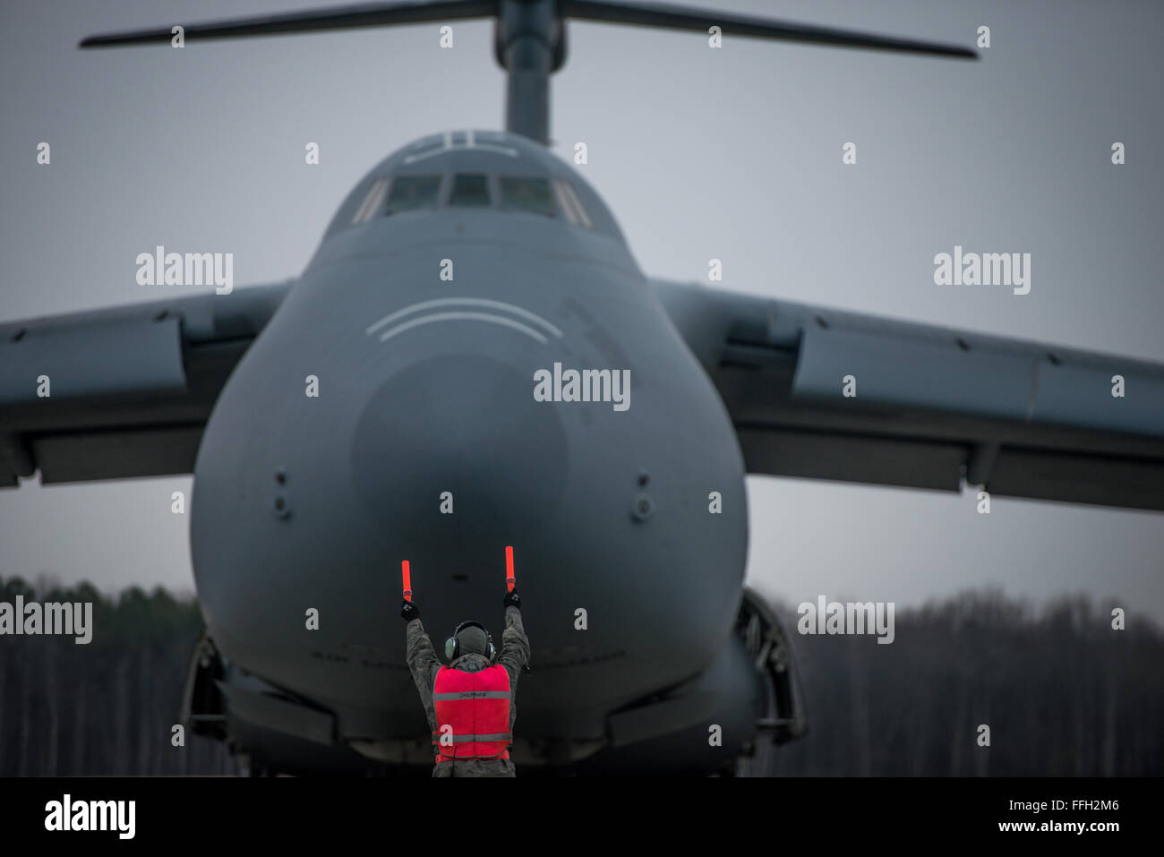 Un aviatore con il 436th Manutenzione aeromobili squadrone esegue il marshalling di un C-5 Galaxy nella corretta posizione di parcheggio dopo essere sbarcati da una missione alla Dover Air Force Base, Delaware. Foto Stock