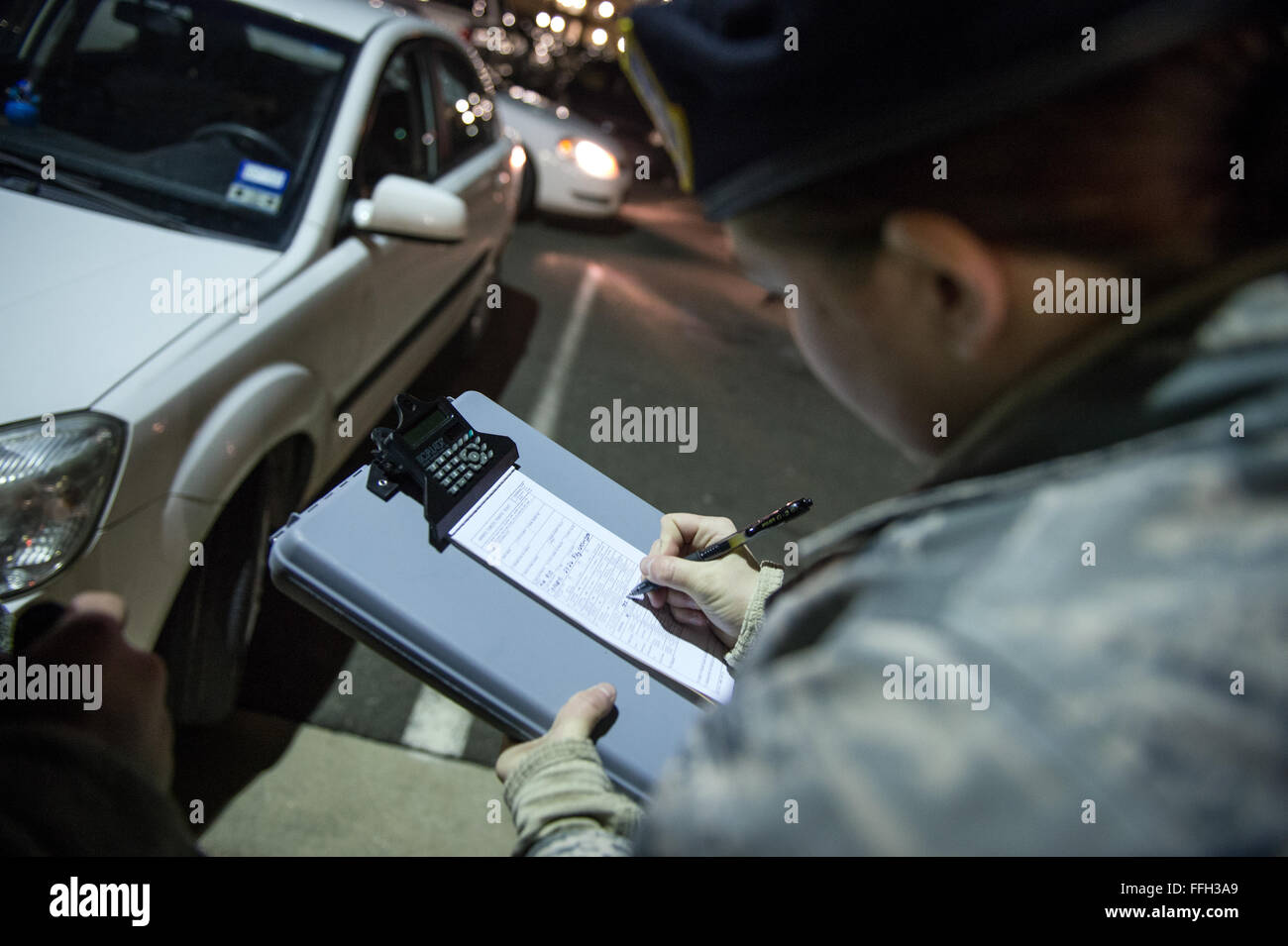 Airman 1. Classe Kaitlyn Evans si prepara un veicolo i biglietti per il parcheggio durante la sua notte-shift dazio a base comune Andrews, Maryland. Evans mantiene proficiency bilanciando nel contempo la sua carriera e la proprietà di un cavallo con il supporto da parte di amici e familiari. Ella è un undicesimo delle forze di sicurezza patrolman squadrone della Andrews Air Force Base in Maryland. Foto Stock