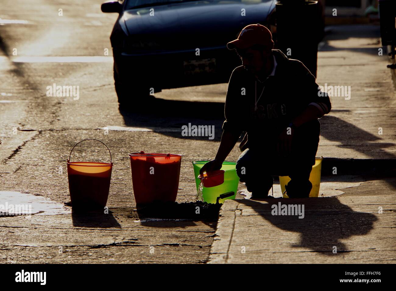 Un lavoratore la miscelazione di cemento in silhouette. Foto Stock