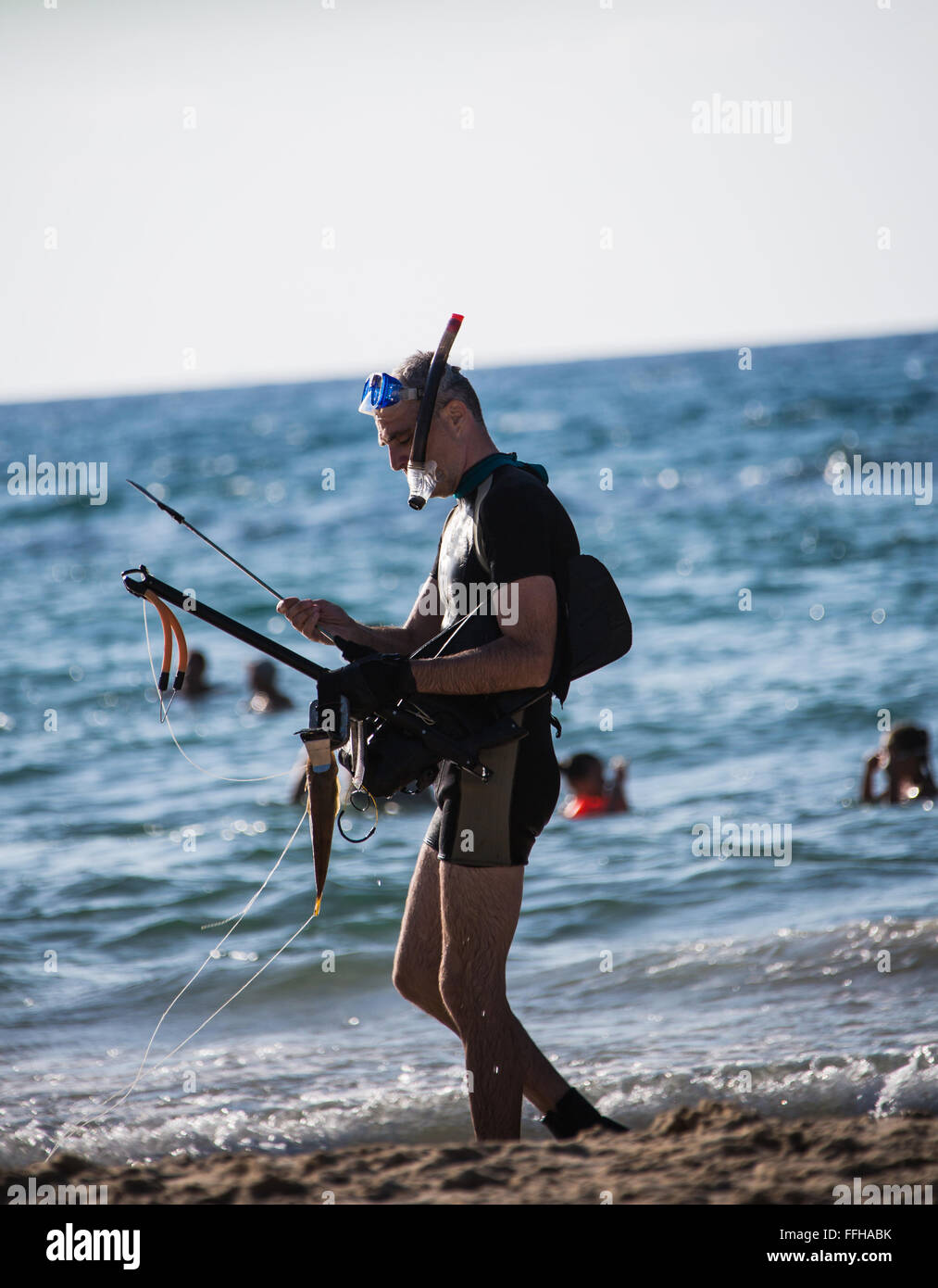 Uomo che indossa una maschera per le immersioni sorge sulla riva Foto Stock