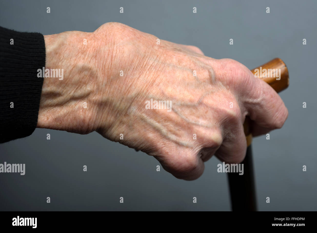 La vecchiaia titolare di pensione o di rendita con mano sul bastone da passeggio Foto Stock