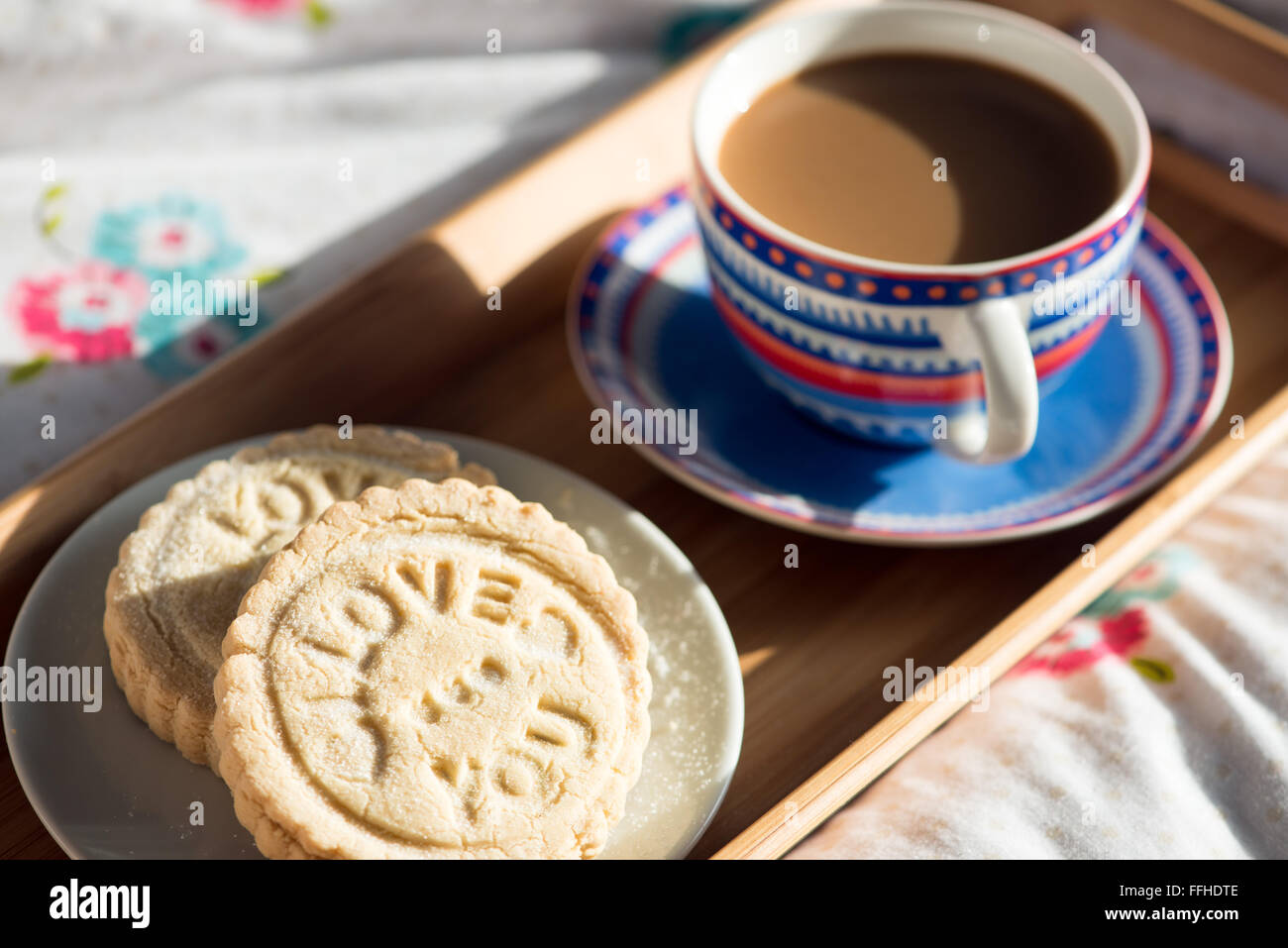 Fresco di giornata, artigianale di biscotti frollini stampati con le parole, ti amo. Servito con il caffè su un vassoio Foto Stock