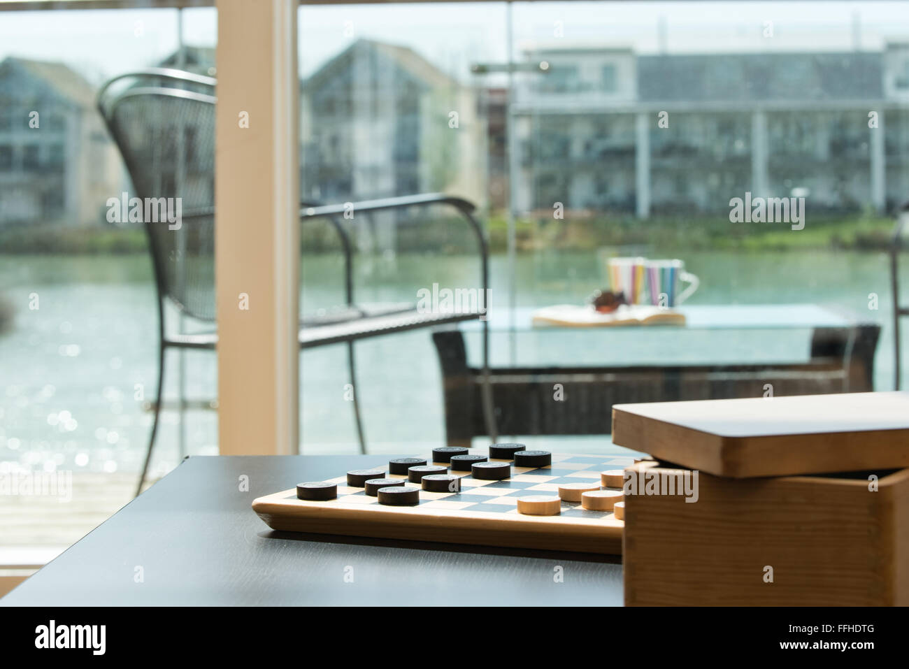 Una scheda di dama, impostare, in attesa di avversari per avviare un gioco in una casa vacanze con vista sul mare Foto Stock