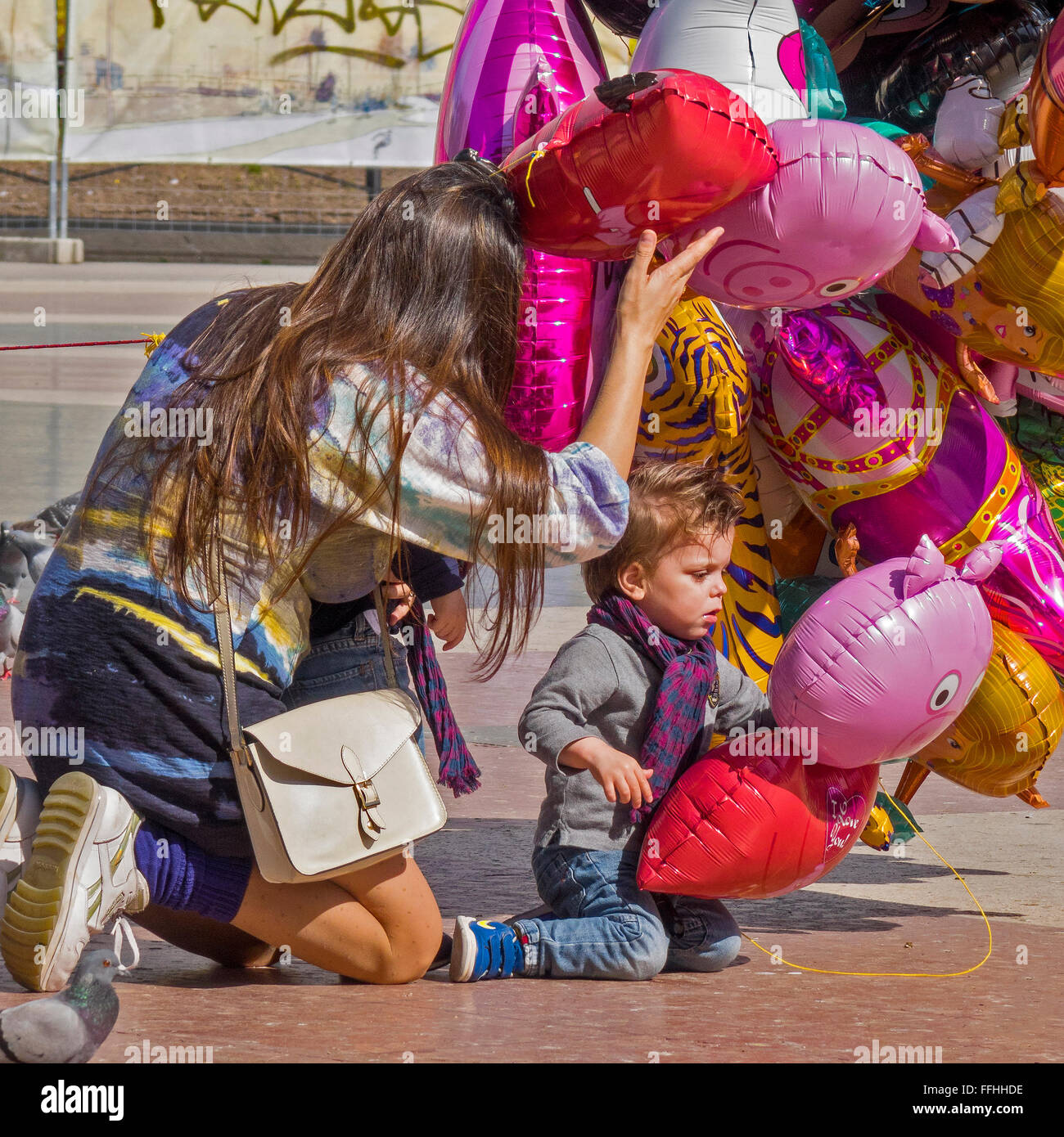 La madre e il Bambino scegliendo un palloncino Barcellona Spagna Foto Stock