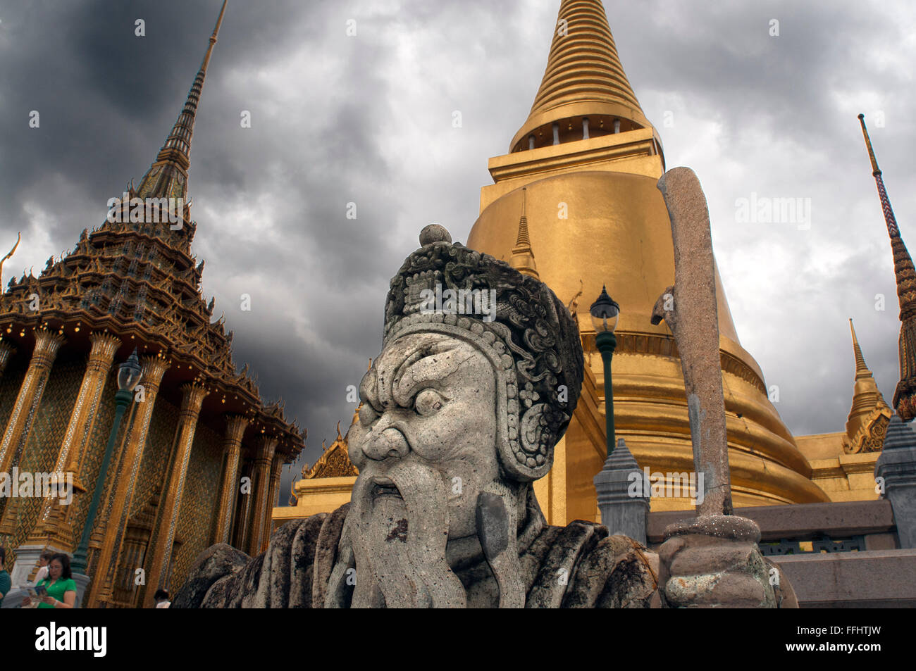 Stupa dorato e pietra custode di Wat Phra Kaew vicino al Gran Palazzo Reale di Bangkok in Thailandia. Custode gigante nella parte anteriore del Phra Sri Foto Stock