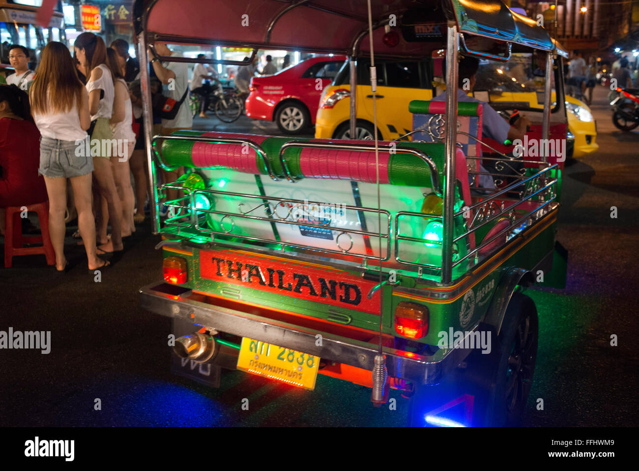 Un tuk tuk taxi in strada. Visualizza in basso Thanon Yaowarat road a notte nel centro di quartiere Chinatown di Bangkok in Thailandia. Yaowarat Foto Stock