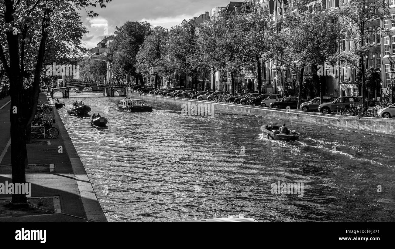 Scena di Amsterdam Canale d'acqua e barche in Amsterdam. Visualizzazione Bianco e nero sul turista e imbarcazioni al Nieuwe Herengracht Canal. Foto Stock