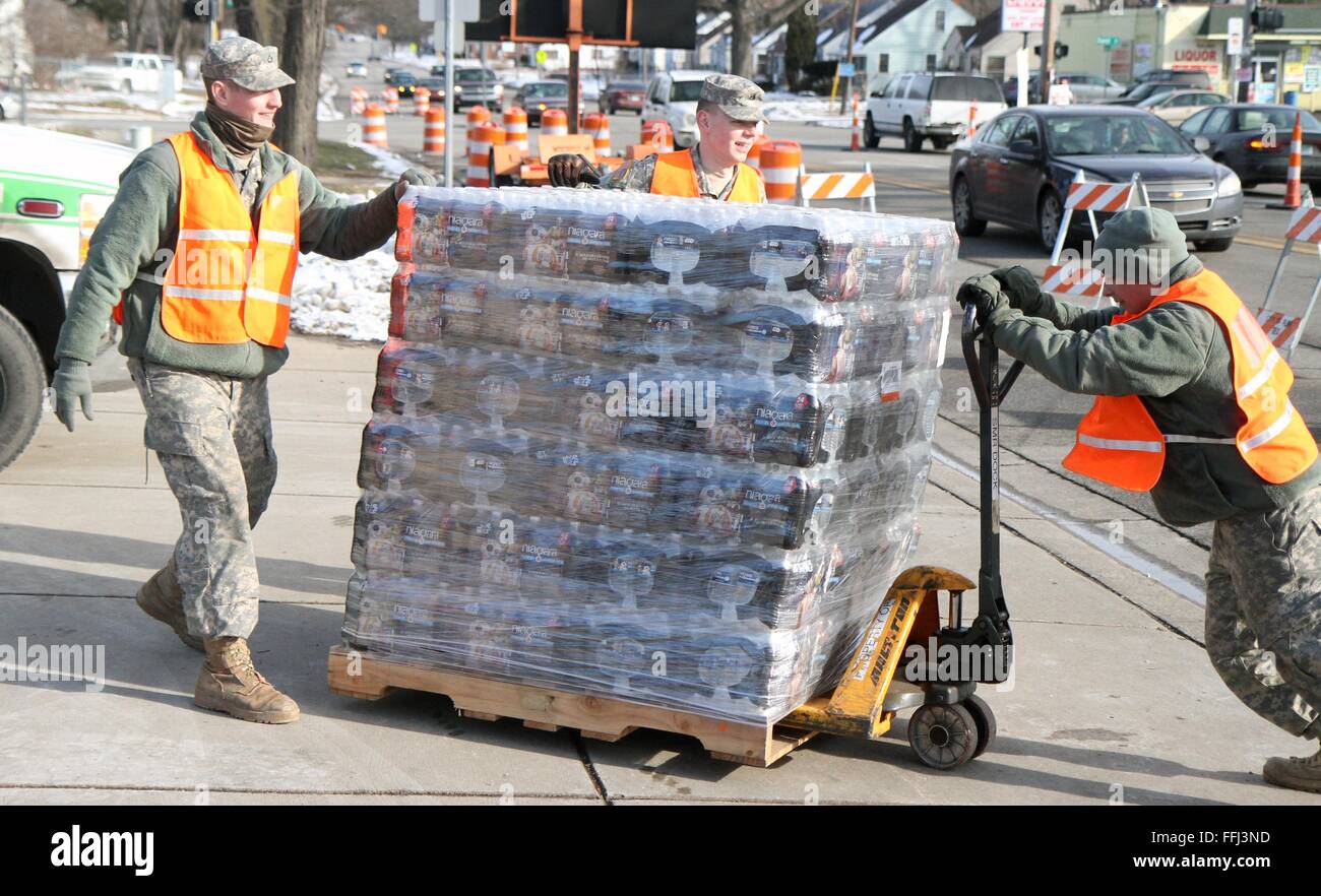 U.S Air Force avieri con il Michigan Air National Guard scarico acqua in bottiglia per la distribuzione ai residenti effettuate da contaminazione di piombo nella città di acqua potabile Gennaio 22, 2016 di Flint, Michigan. Come molti come 12.000 bambini sono stati esposti a pericolosi acqua potabile dopo il governo dello stato commutato approvvigionamenti di acqua senza rispettare norme federali sulla sicurezza. Foto Stock