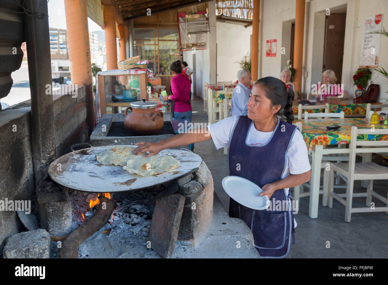Santiago Matatlán, Oaxaca, Messico - Un ristorante lavoratore rende la tortilla di grandi dimensioni tipiche di Oaxaca su un comal. Foto Stock