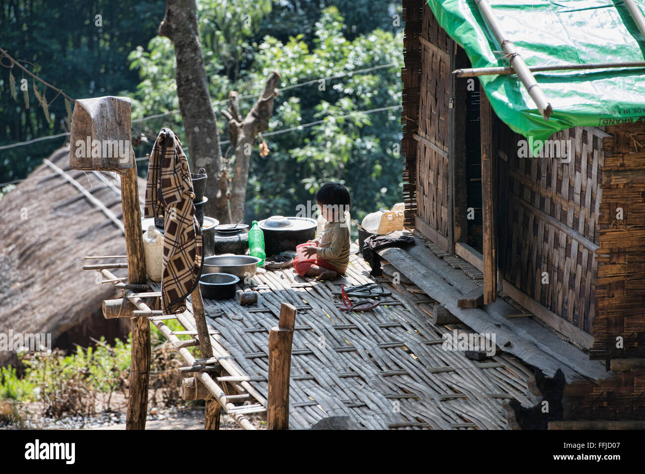 Ragazzo su un portico nel rurale Stato Chin, Myanmar Foto Stock