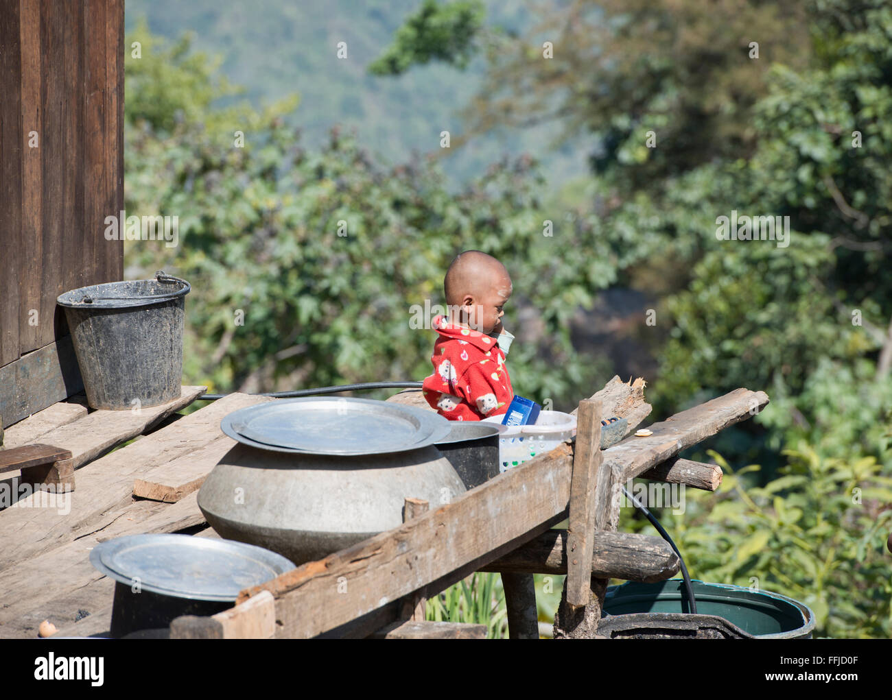 Ragazzo su un portico nel rurale Stato Chin, Myanmar Foto Stock