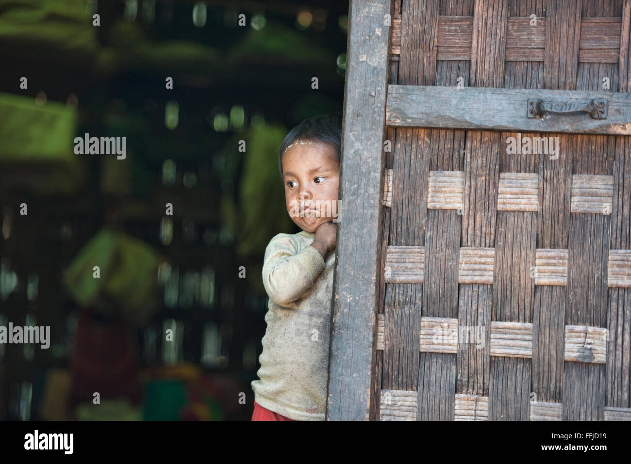 Ragazzo coetanei dalla sua famiglia capanna in rurale Stato Chin, Myanmar Foto Stock