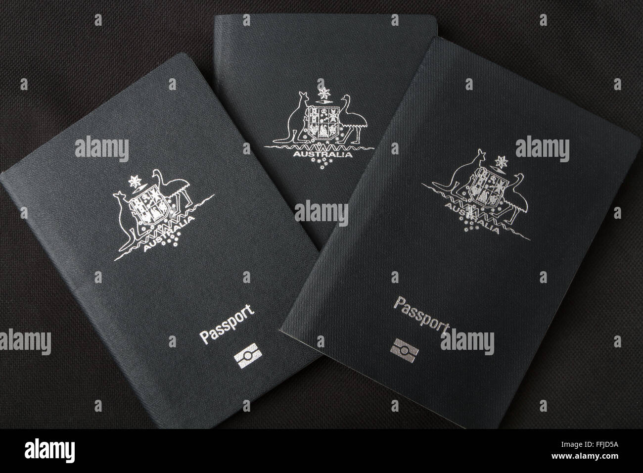 Tre passaporti australiano su uno sfondo nero. Foto Stock