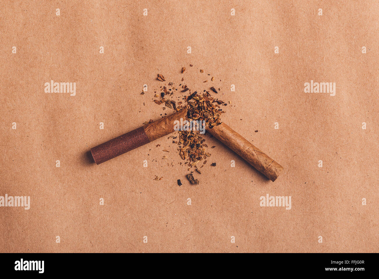 Rotto cigarette top vista su carta marrone, smettere di fumare concetto, calda retrò tono dell'immagine. Foto Stock