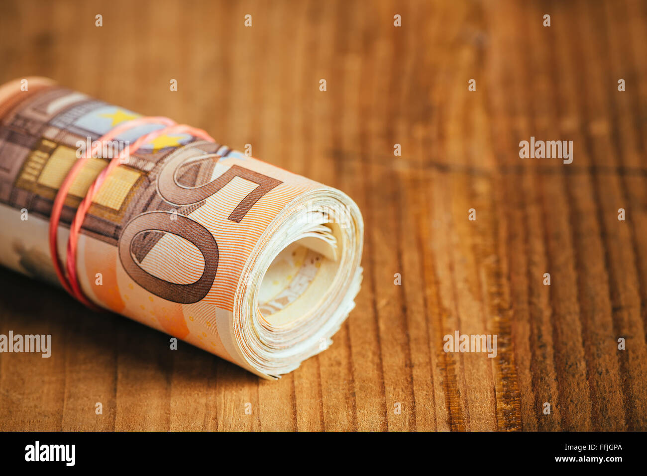 Risparmio di denaro concetto, arrotolato in denaro contante con fascia di  gomma sulla scrivania in legno, cinquanta euro banconote personal home  budget pila Foto stock - Alamy