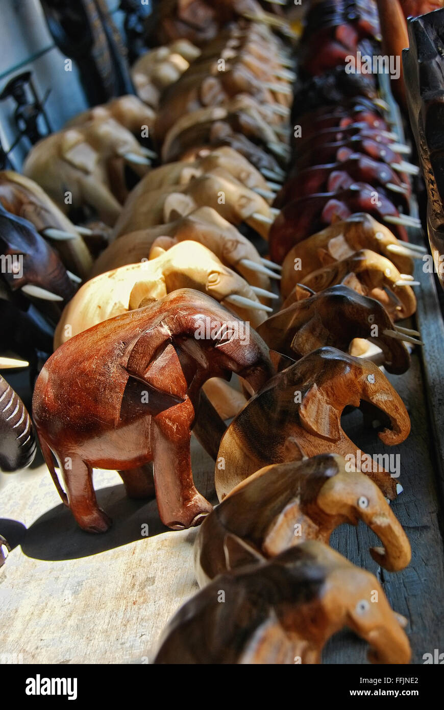Riga di legno intagliato elefanti sorge su una scheda all'aperto, nello Sri Lanka Foto Stock