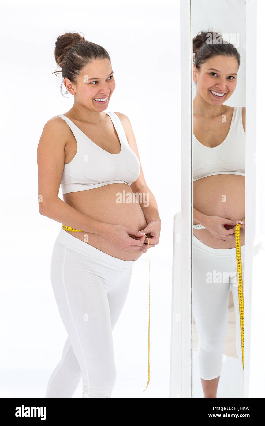 Asian donna incinta misurando il suo ventre Foto Stock
