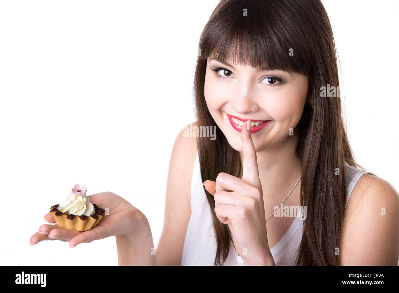 Ritratto di giovane bella donna sorridente tenendo nel suo palm crostata deliziosa torta con crema e cioccolato nel cesto di pasta Foto Stock