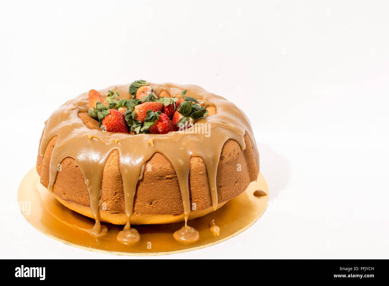 Toffee Bundt torta decorata con salsa al caramello e fragole Foto Stock