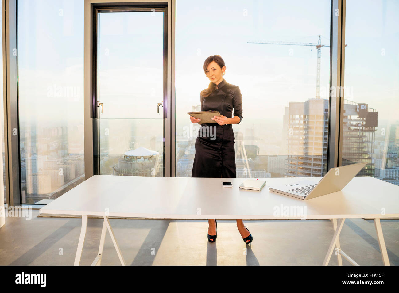 Architetto femmina in office contro Urban Skyline Foto Stock