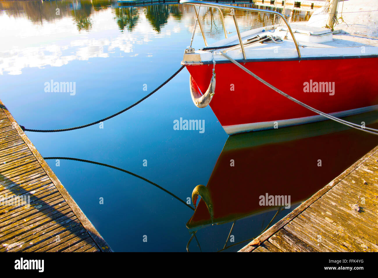 Riflessioni sull'acqua di una barca a vela sul lago Foto Stock