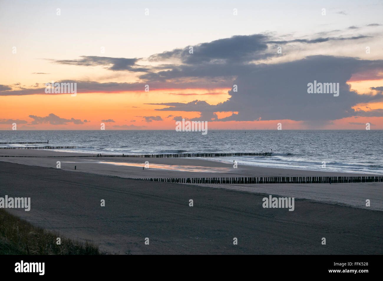 Tramonto, spiaggia sabbiosa, groyne, Westkapelle vicino a Domburg, costa del Mare del Nord, Zeeland, Paesi Bassi Foto Stock