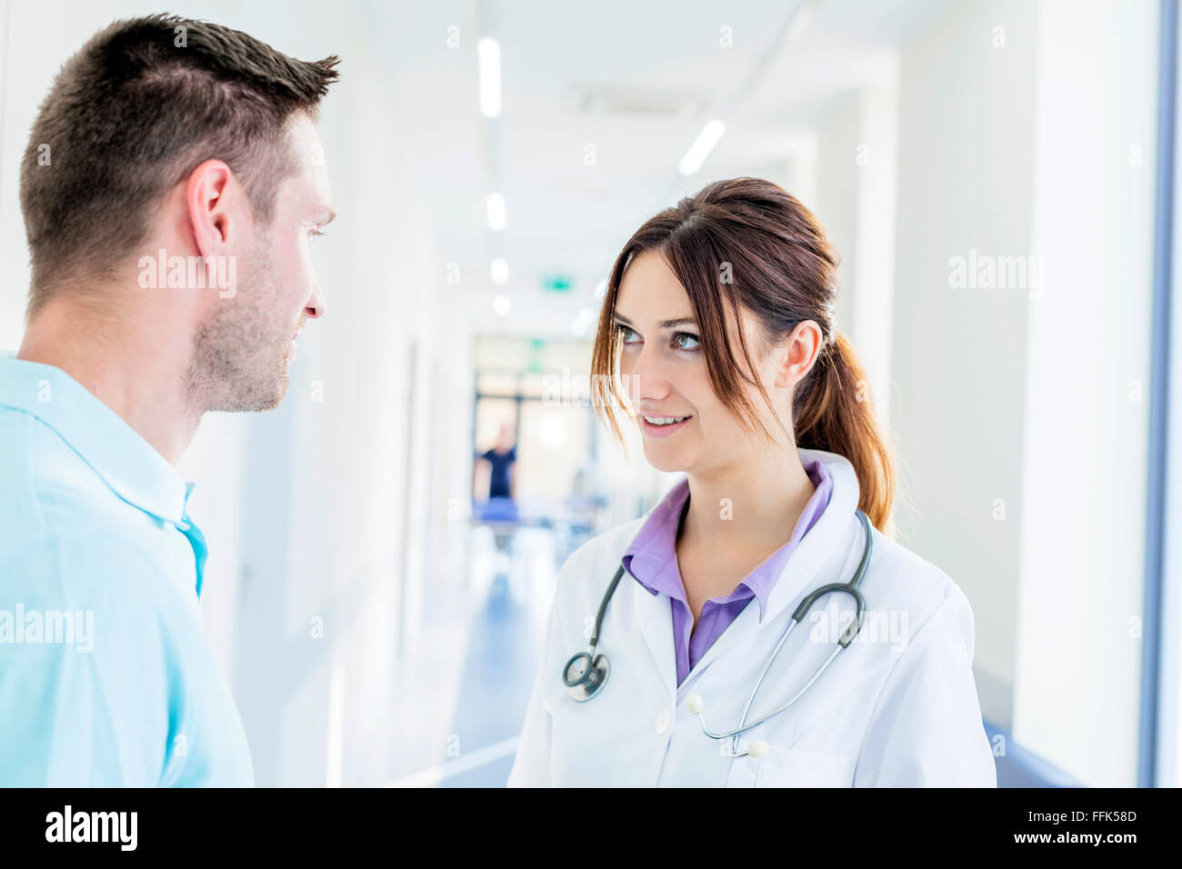 Maschio e femmina medico parlando in ospedale corridoio Foto Stock