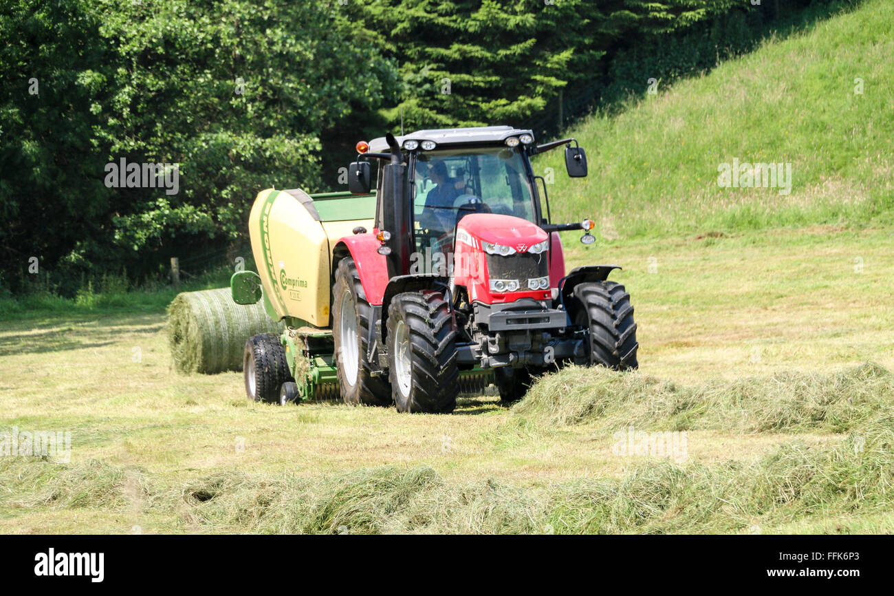 Coltivatore di fieno di impilamento con il suo trattore, Carlton, Yorkshire Dales, Inghilterra Foto Stock