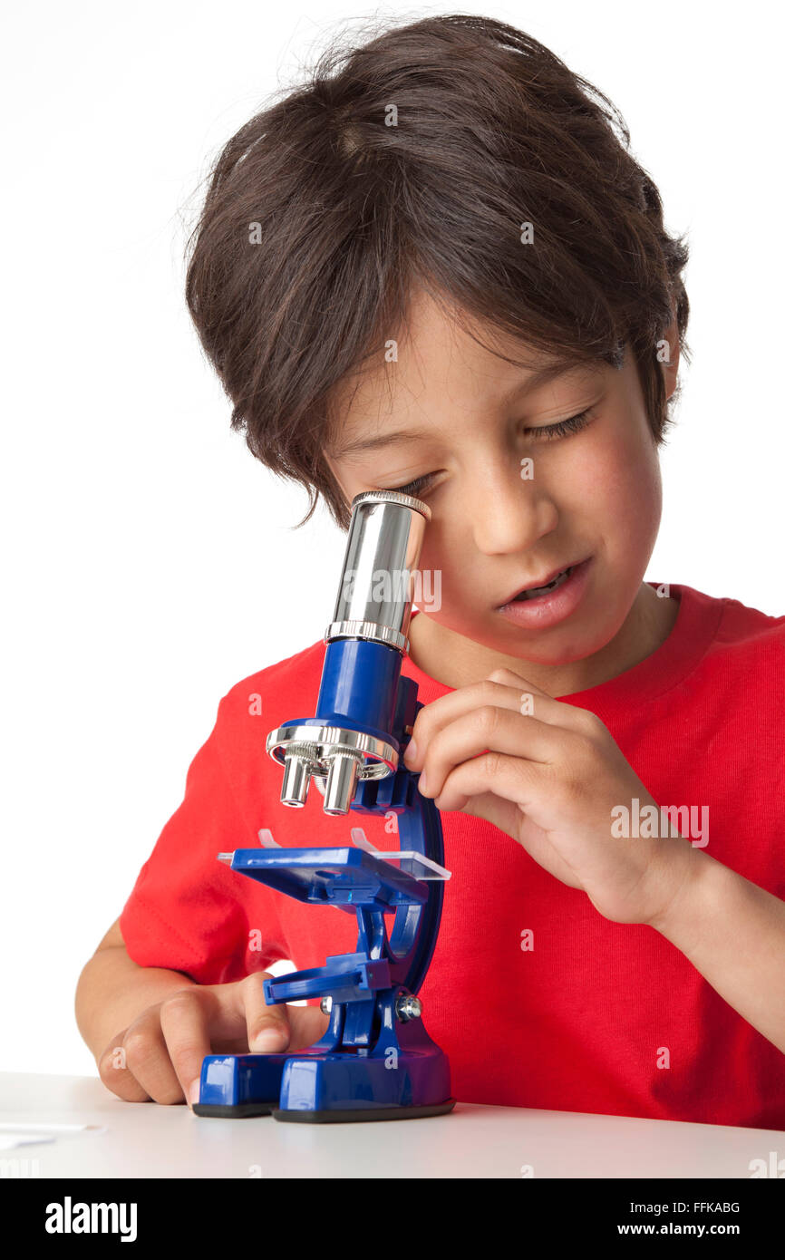 Little Boy guardando attraverso un microscopio su sfondo bianco Foto Stock