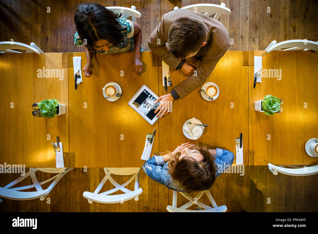 Amici utilizzando la tavoletta digitale nel ristorante Foto Stock