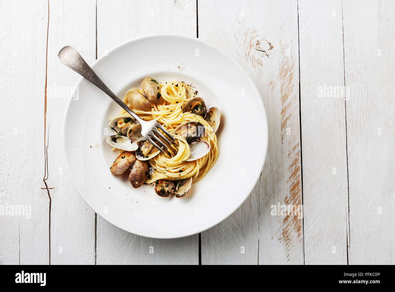 Piatti di pasta con le vongole Spaghetti alle Vongole in bianco sullo sfondo di legno Foto Stock