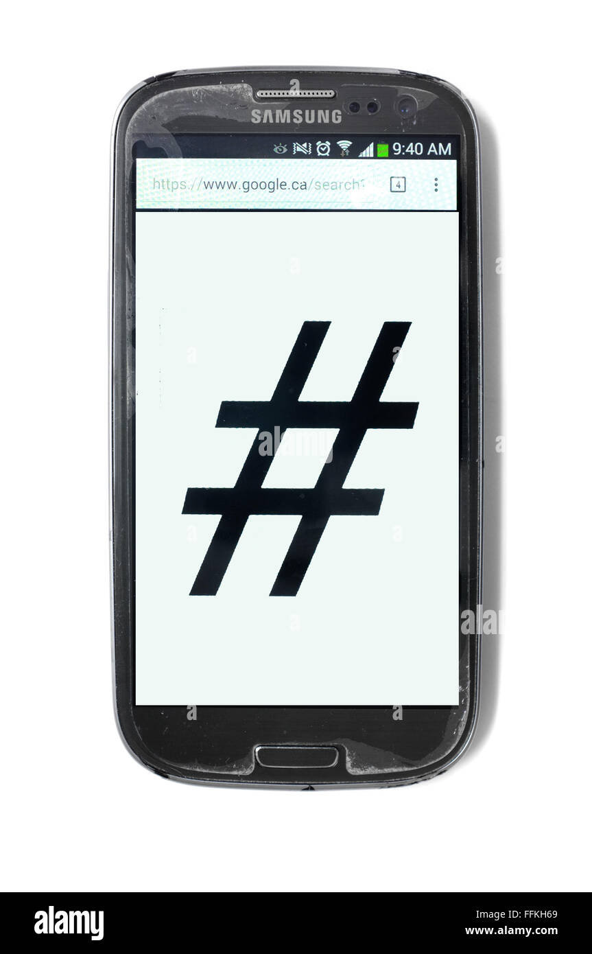 Il simbolo di hashtag scritto su una schermata dello smartphone fotografati contro uno sfondo bianco. Foto Stock