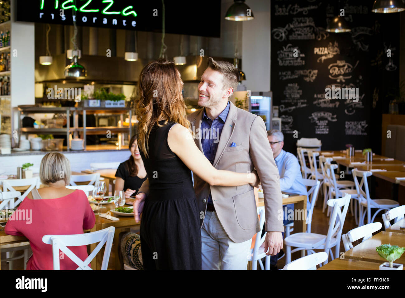Gruppo di amici a celebrare in ristorante Foto Stock