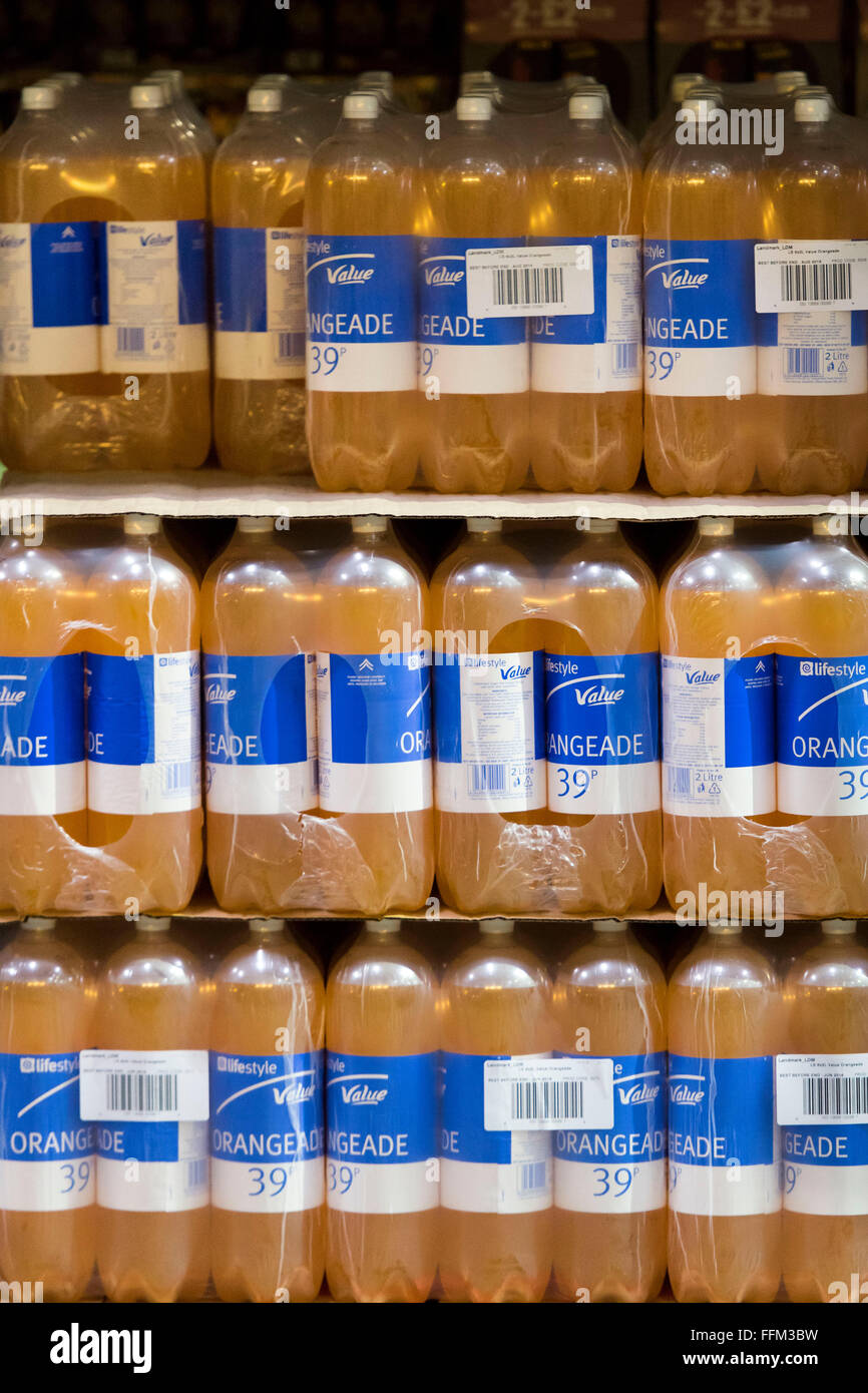 Il valore di bilancio di bottiglie di orange soft drink impilati in un magazzino. Foto Stock