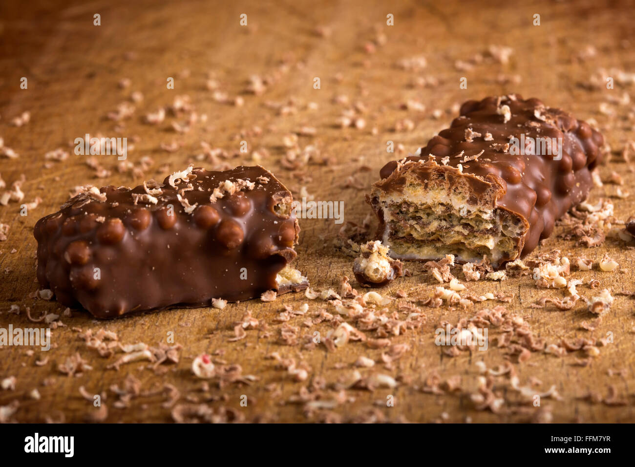 Barra di cioccolato con caramello e dado con wafer su sfondo di legno Foto Stock