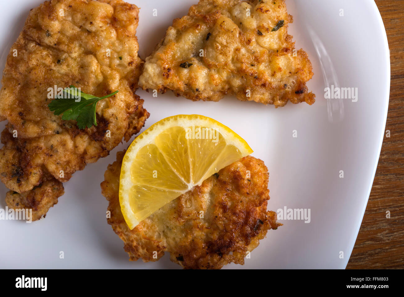 Cotoletta chop cotoletta con limone e prezzemolo su una piastra bianca Foto Stock