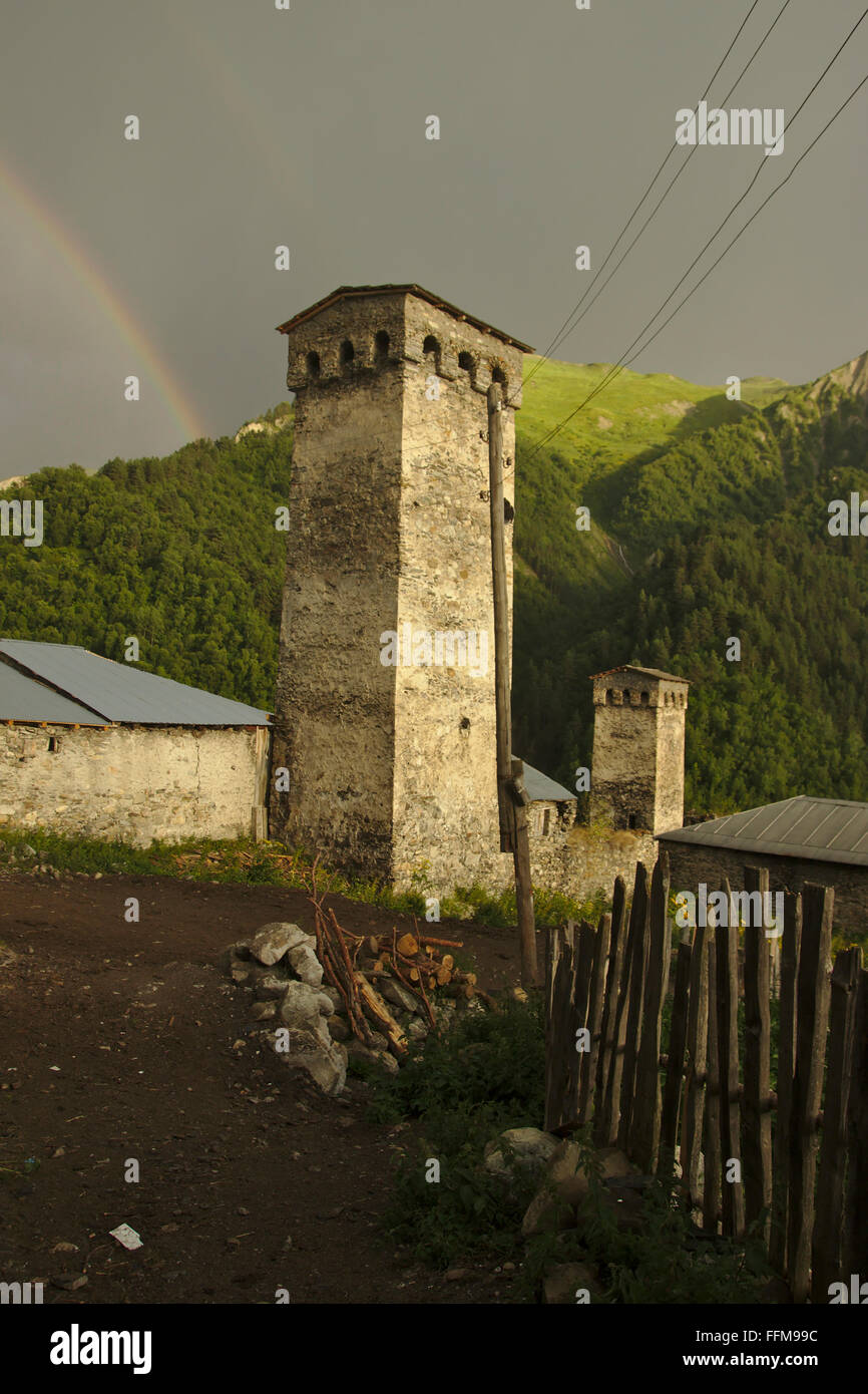 Atmosfera serale, torri di difesa del villaggio Adishi, nuvole scure, una luce calda e Rainbow. Mestia-Ushguli-Trek, Svaneti, Georgia Foto Stock