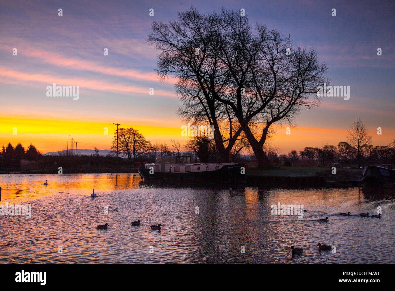 Rufford, Burscough, Preston, Lancashire, Regno Unito. Il 16 febbraio, 2016. Regno Unito: Meteo cieli nastrati all'alba. Un molto freddo ma colorate per iniziare la giornata per houseboat residenti presso il St Mary's Marina, sul Leeds Liverpool canal. Foto Stock