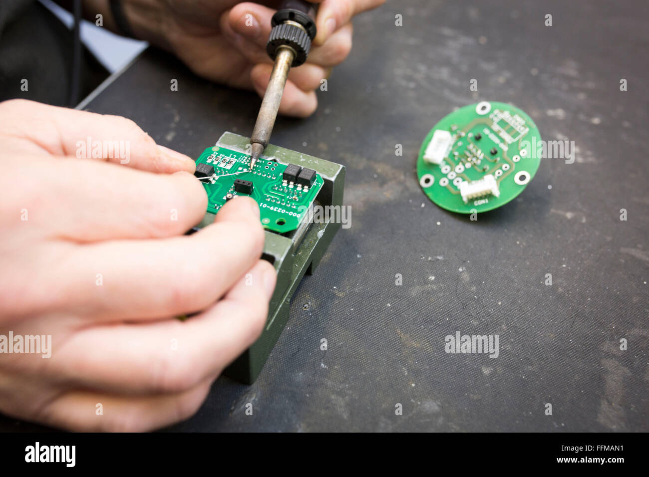 Close up di un lavoratore la saldatura di una scheda di circuito Foto Stock