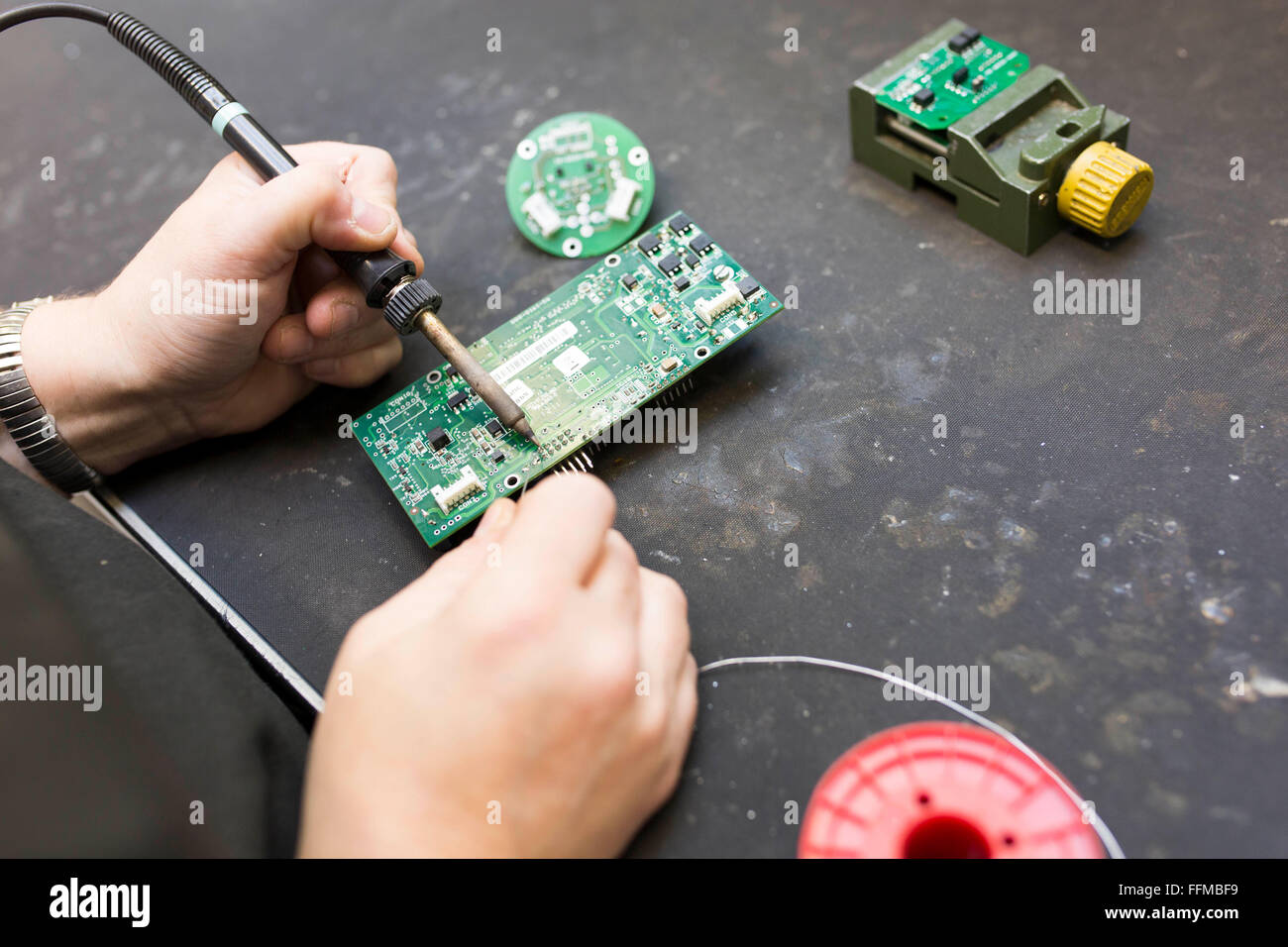 Close up di un lavoratore la saldatura di una scheda di circuito Foto Stock