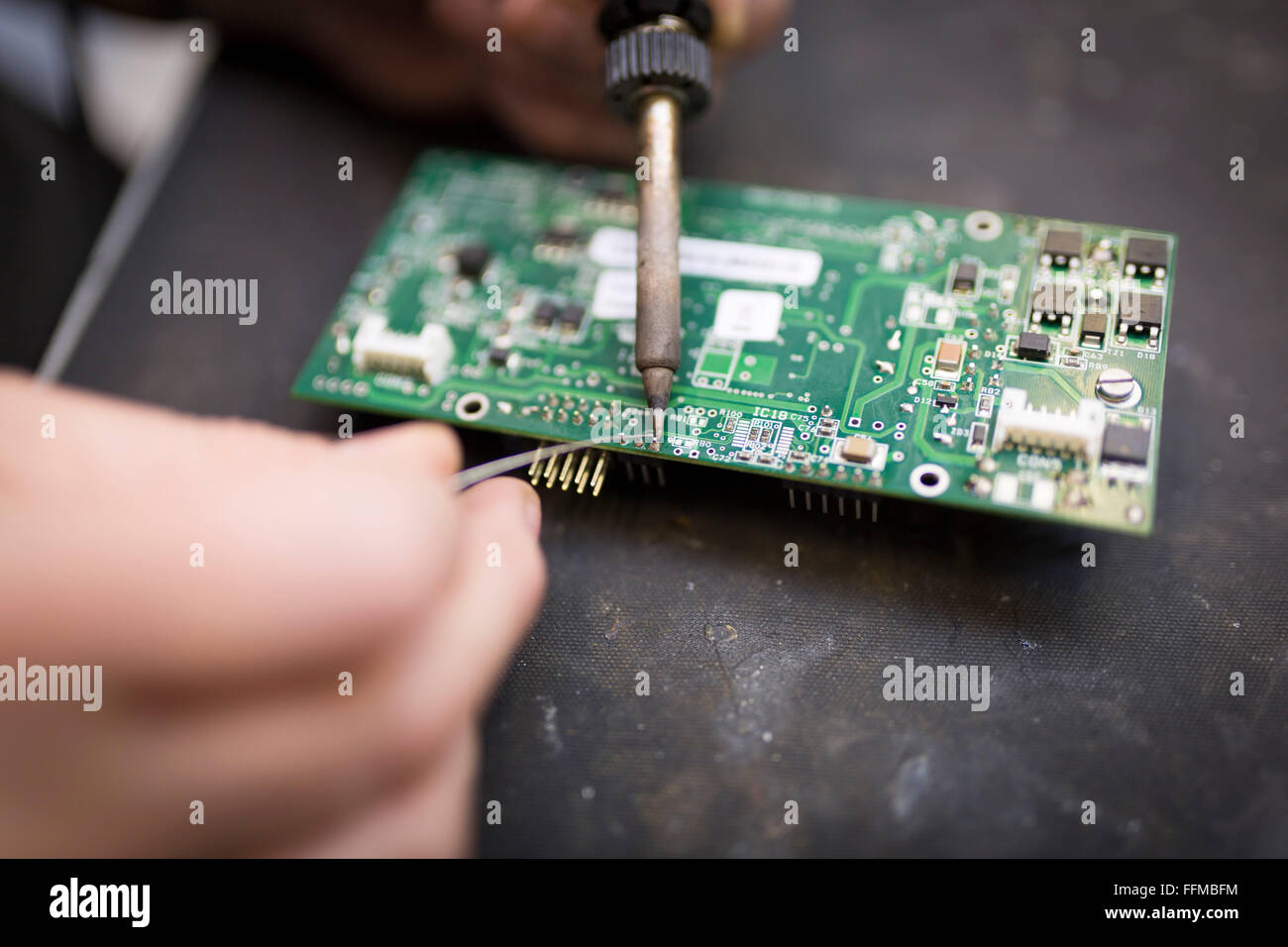 Close up di un lavoratore la saldatura di una scheda di circuito Foto Stock