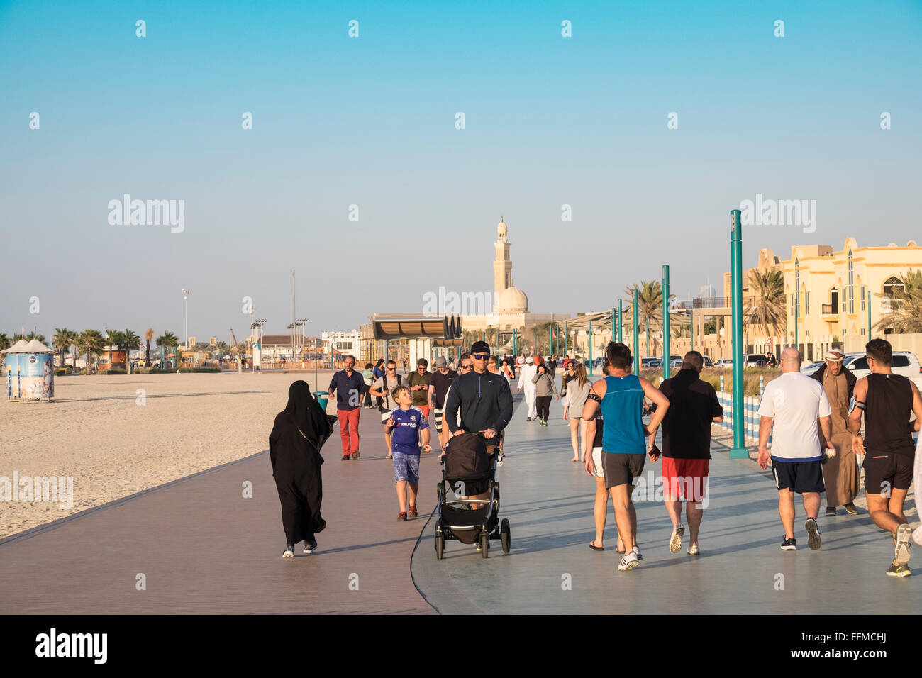 Molte persone utilizzano nuovo pubblico Boardwalk e pista da jogging accanto alla spiaggia in Dubai Emirati Arabi Uniti Foto Stock