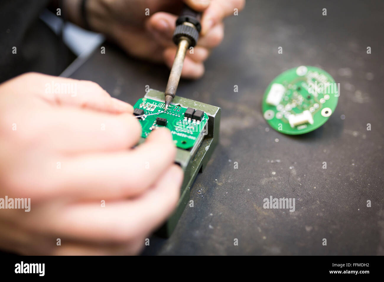 Close up di un lavoratore la saldatura di una scheda di circuito Foto Stock