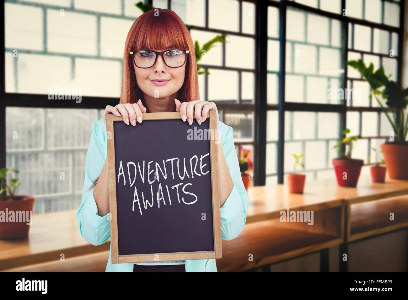 Immagine composita di sorridere hipster donna holding di Blackboard Foto Stock