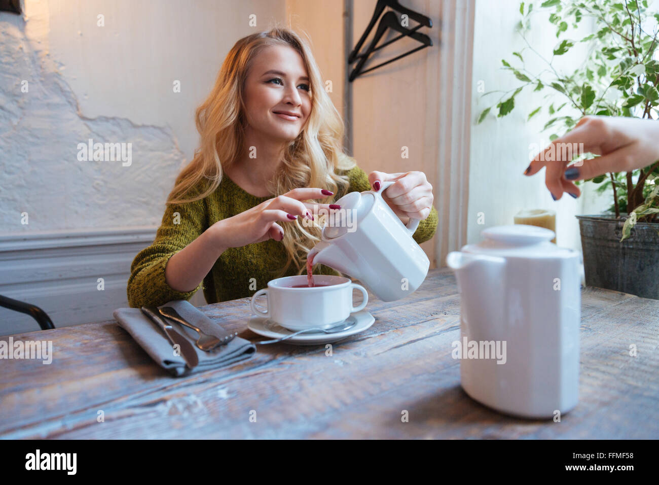 Bella giovane donna bere il tè in cafe Foto Stock